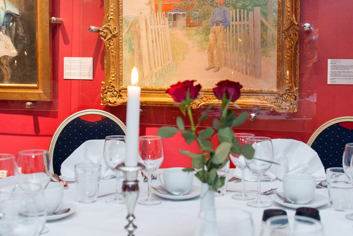 Elegant restaurangbord med röda rosor och tavlor