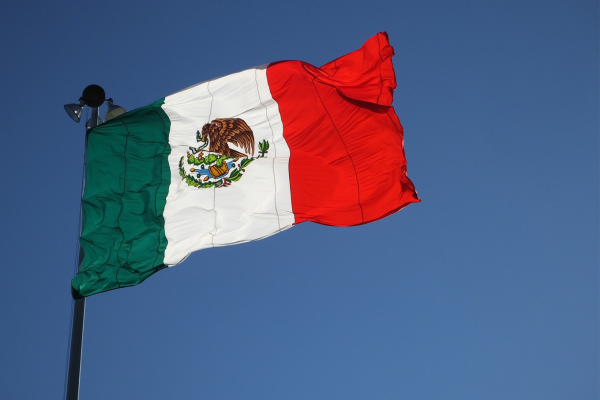 Mexikos flagga vajar mot blå himmel