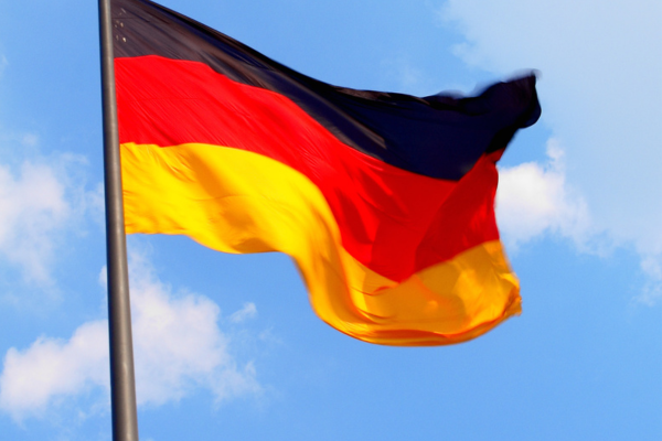Tysklands flagga vajar mot blå himmel